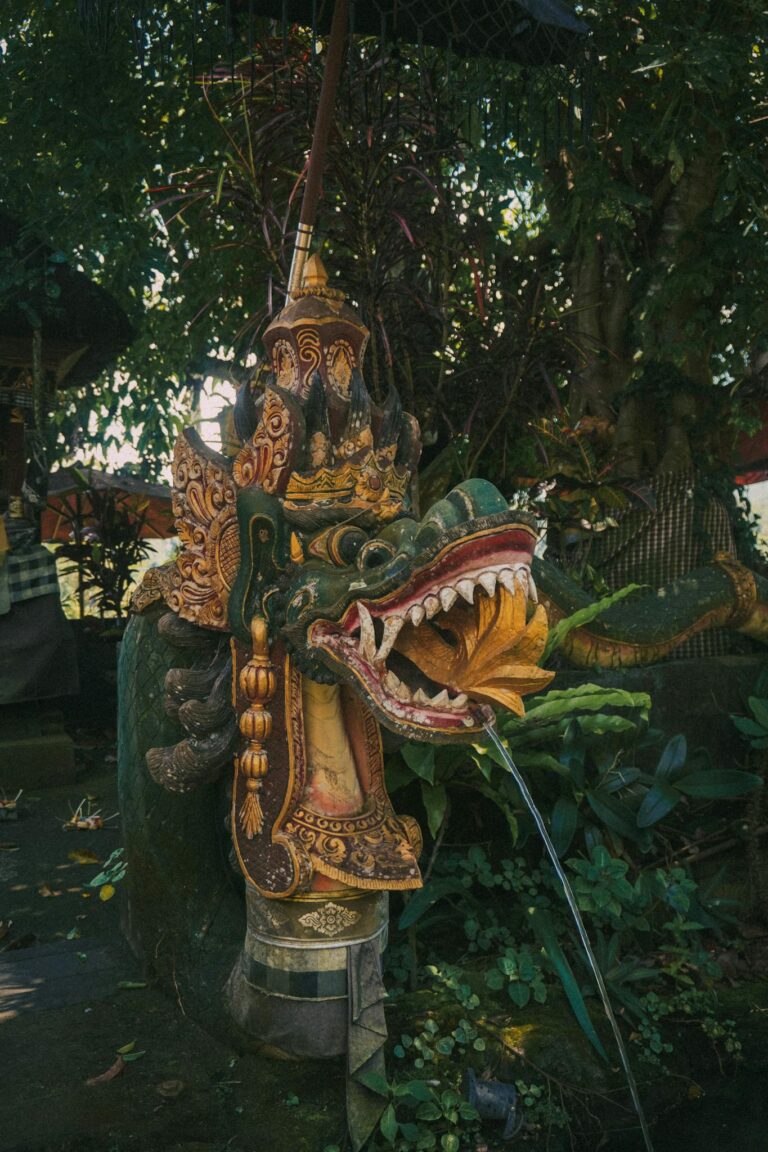 Detailed dragon sculpture surrounded by vibrant forest plants, exuding spirituality and tradition.